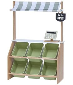 a wooden shelf with six green dishes and a sign that says we are off - ex