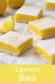 lemon bars with powdered sugar on top and sliced lemons in the back ground