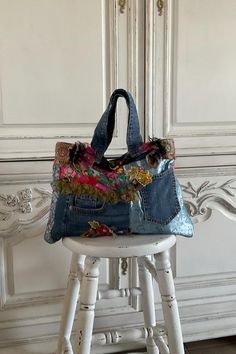 a handbag sitting on top of a stool in front of a white wall and door