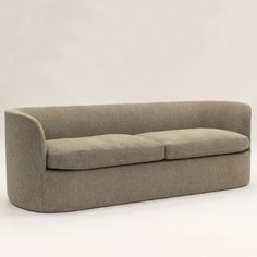 a beige couch sitting on top of a white floor