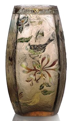 a glass vase with birds and flowers painted on it