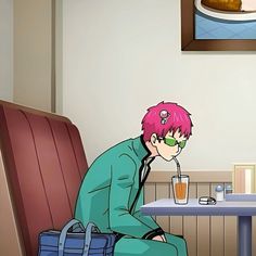 a man with pink hair sitting at a table in front of a bag and drink