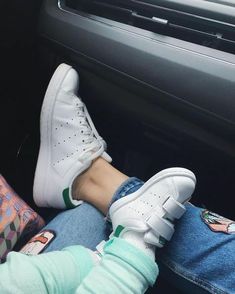 a person sitting in the passenger seat of a car with their feet on the steering wheel