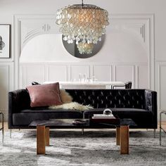 a living room filled with furniture and a chandelier hanging over the top of it