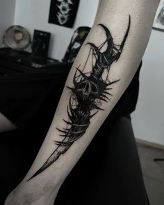 a black and white photo of a tattoo on the arm, with an image of a demon