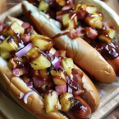 two hot dogs with toppings sitting on a tray