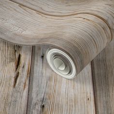 a roll of white paper sitting on top of a wooden floor