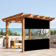 an outdoor gazebo with black curtains and white furniture on the patio next to the ocean