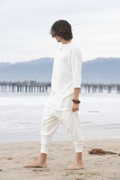 "Pure white stretch cotton harem pants for men. -Edgy -Stretch -Relaxed fit -2 side pockets -Elastic waistband and leg cuffs Great for Yoga, Dance, Exercises, Meditations, Kundalini Yoga Practice and beyond... Materials: ivory white cotton (90% cotton 10% lycra) Fabrics for this pair were bought in Fashion District, LA and the pant was handmade in one of our studios in California. Measurements: Fits: S, M, M/L -Length: 41\" (~104 cm) -Waist: 30\" - 40\" (76 - 100 cm) Style it with high heels or Dance Exercises, Meditation Outfit, White Yoga Pants, Samurai Pants, Yoga Kundalini, Harem Pants Men, Urban Zen, Cotton Harem Pants, Festival T Shirts