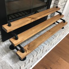 two wooden benches sitting in front of a fireplace