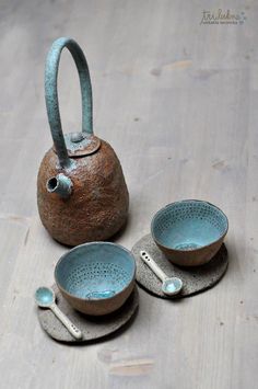 three bowls and a teapot on a wooden table