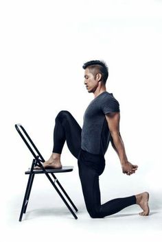 a man is sitting on a chair with his legs spread out and one leg up