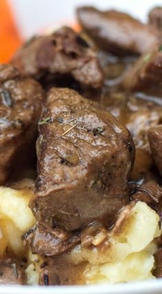 a bowl filled with meat and potatoes covered in gravy