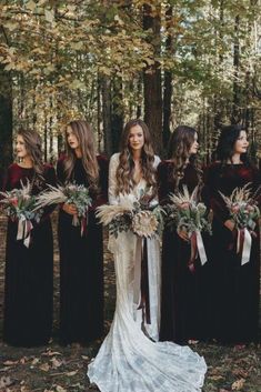 a group of women standing next to each other in front of trees with long hair