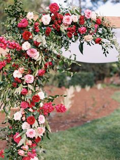 an outdoor ceremony with flowers and greenery