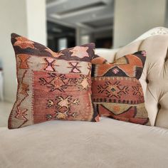 two pillows sitting on top of a couch