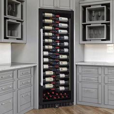 a wine cooler in the middle of a kitchen with gray cabinets and white counter tops