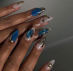 a woman's hand with some blue and white nail polishes on her nails