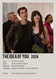 a man and woman standing next to each other in front of a poster for the idea of you