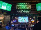 a man standing in front of a bar filled with lots of tv screens