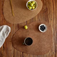 two placemats with olives on them and a cup of coffee in the middle