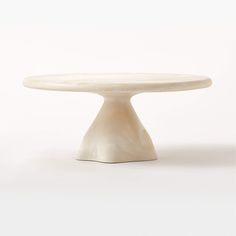 a white cake plate sitting on top of a table