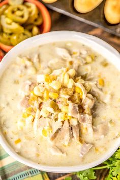 a white bowl filled with corn and chicken chowee next to other bowls of food