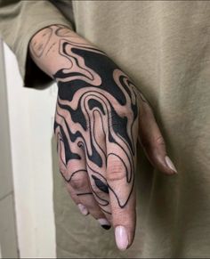 a person with a black and white tattoo on their hand