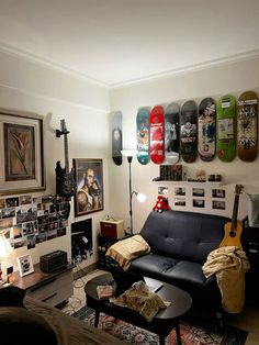 a living room filled with furniture and lots of skateboards on the wall above it