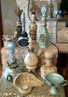 a table topped with lots of different types of bottles and vases on top of a table