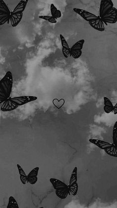 black and white photograph of butterflies flying in the sky with a heart shaped cloud behind them