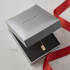 a silver box with a red ribbon around it