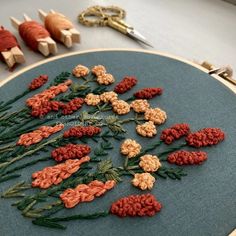 there are many crocheted flowers on the embroiderying board with scissors next to it