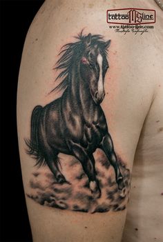 a black and white horse tattoo on the back of a man's shoulder