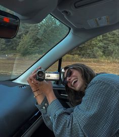 a woman taking a photo in the back seat of a car with her digital camera