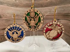 three medals are hanging from clear acrylic stands on a wooden table with wood planks in the background