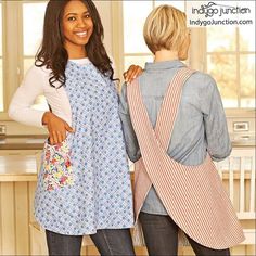 two women in aprons standing next to each other with one holding an apron over her shoulder