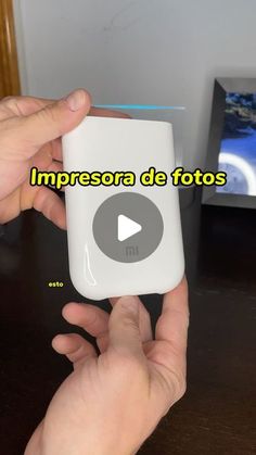 a person holding an mp3 player in their hand with the caption impresora de fotos