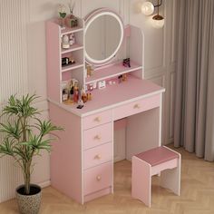 a pink vanity with mirror and stool next to a potted plant