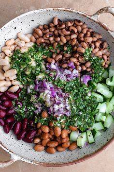 a bowl filled with beans, broccoli and cucumbers