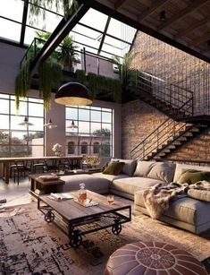 a living room filled with lots of furniture and plants hanging from the ceiling next to a brick wall