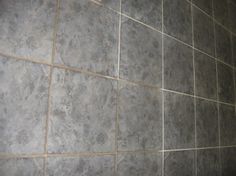 a tile wall in a bathroom with no shower curtain