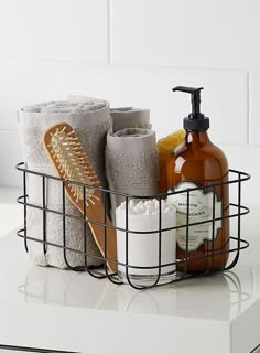 a bathroom basket filled with toiletries on top of a counter