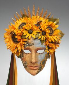 a woman with sunflowers on her head wearing a mask that is made out of wood