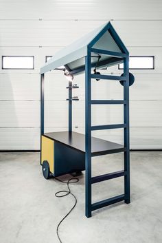 a blue and yellow bunk bed sitting inside of a garage next to a white wall