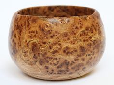 a close up of a wooden bowl on a white surface