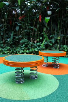 an outdoor play area with two circular tables