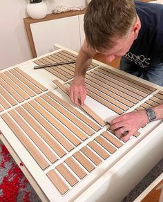 a man is working on some wood planks that are being assembled into a table