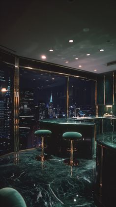 a kitchen with green marble counter tops and stools in front of a large window