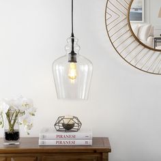 a lamp that is on top of a table next to some books and vases